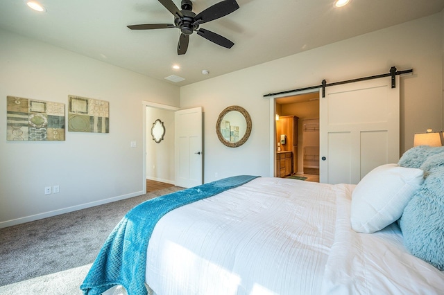 bedroom featuring carpet, a barn door, ceiling fan, and connected bathroom