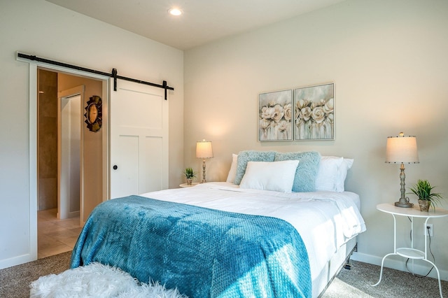 carpeted bedroom with a barn door and a closet