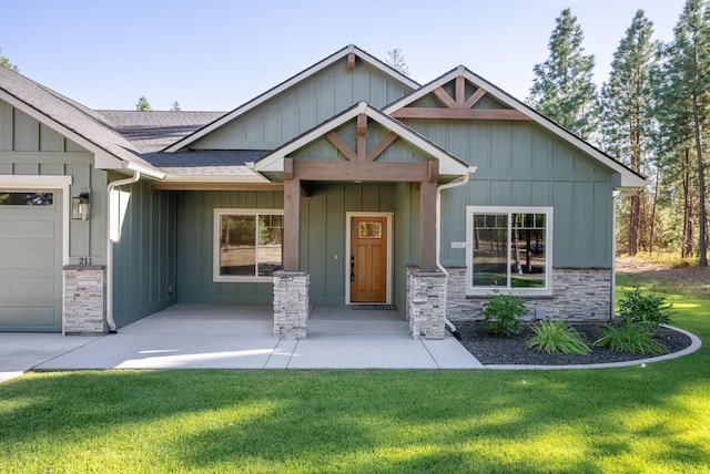 craftsman house with a front lawn and a garage