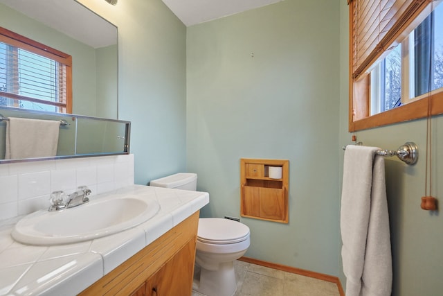 bathroom with tile patterned floors, backsplash, toilet, and vanity