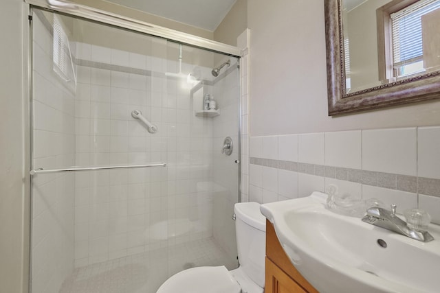 bathroom with vanity, toilet, tile walls, and an enclosed shower