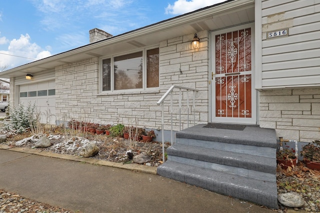 doorway to property with a garage