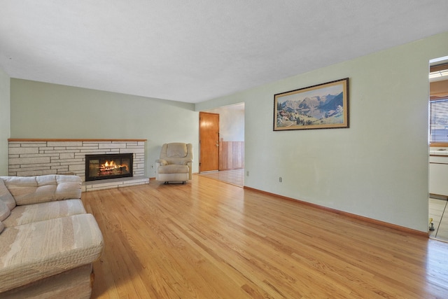 living room with light wood-type flooring and a fireplace