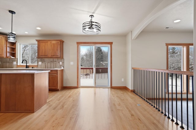 kitchen with backsplash, decorative light fixtures, and a healthy amount of sunlight