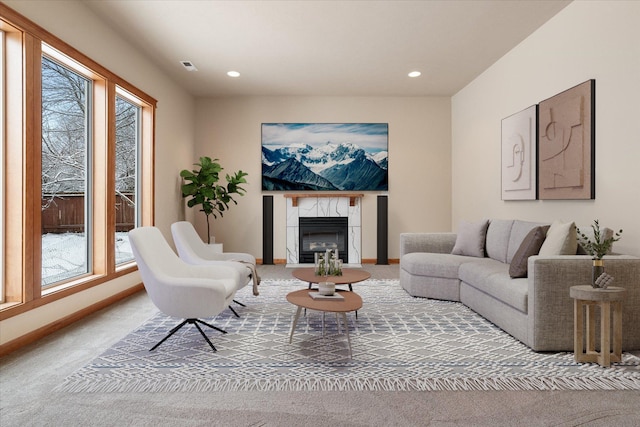 carpeted living room with a premium fireplace and a wealth of natural light