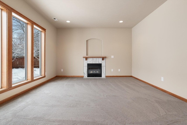 unfurnished living room featuring a fireplace and light colored carpet