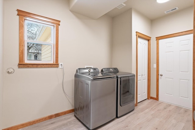 laundry area featuring light wood-type flooring and washer and clothes dryer