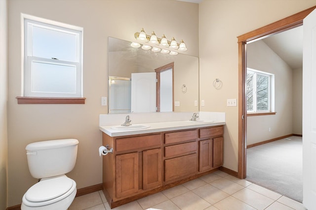 bathroom featuring tile patterned flooring, vanity, toilet, and vaulted ceiling