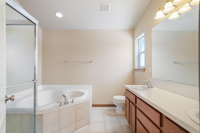 bathroom with tile patterned floors, vanity, toilet, and tiled bath