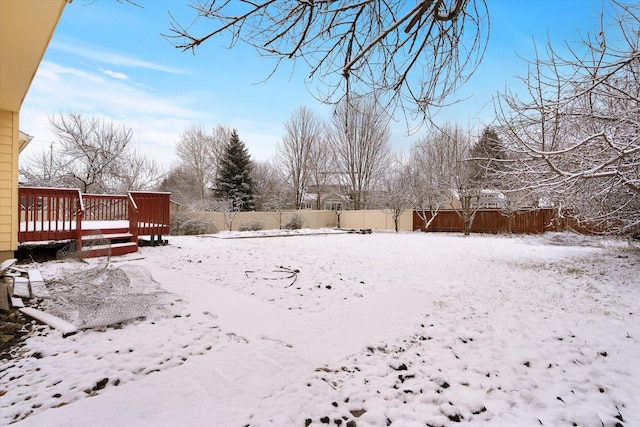 yard covered in snow featuring a deck