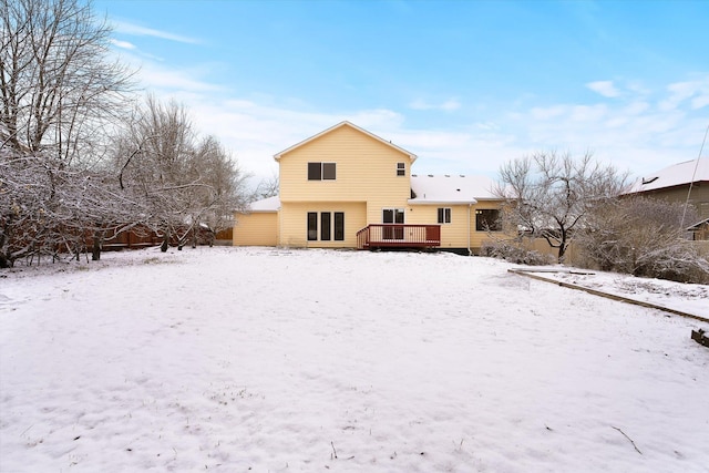 snow covered house featuring a wooden deck