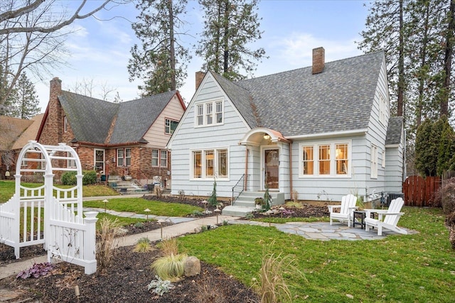 rear view of property with a patio and a lawn