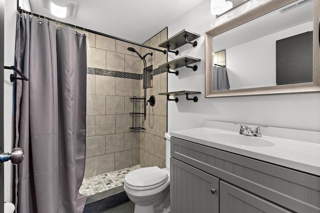 bathroom featuring a textured ceiling, vanity, toilet, and walk in shower