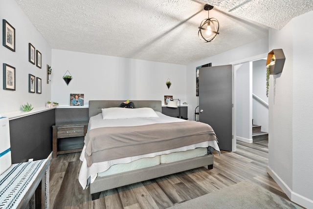 bedroom with hardwood / wood-style floors and a textured ceiling