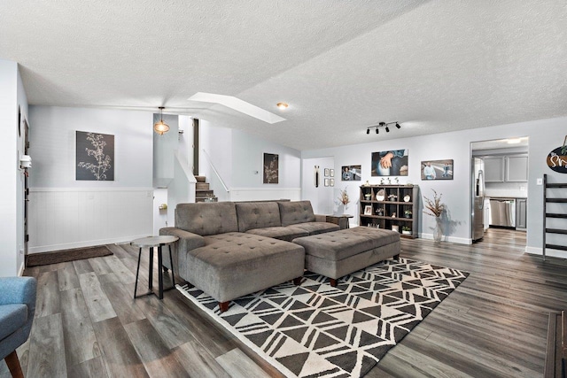 living room with a textured ceiling, hardwood / wood-style flooring, and vaulted ceiling