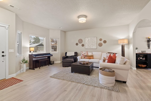 living room with light wood-type flooring and a textured ceiling