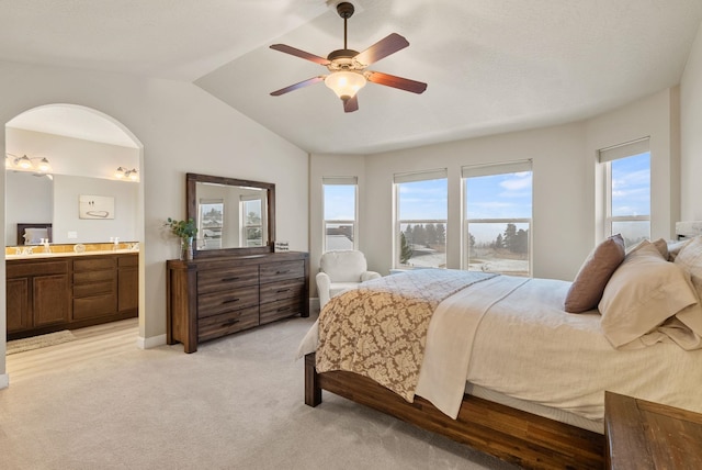 bedroom with ceiling fan, ensuite bathroom, light carpet, and multiple windows