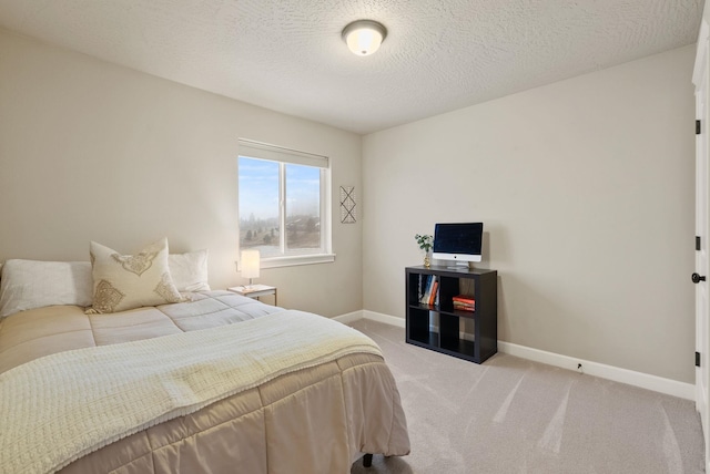 bedroom featuring light colored carpet and a textured ceiling