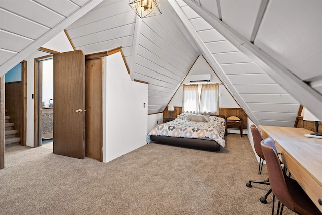 bedroom with vaulted ceiling, carpet floors, an AC wall unit, and ensuite bath