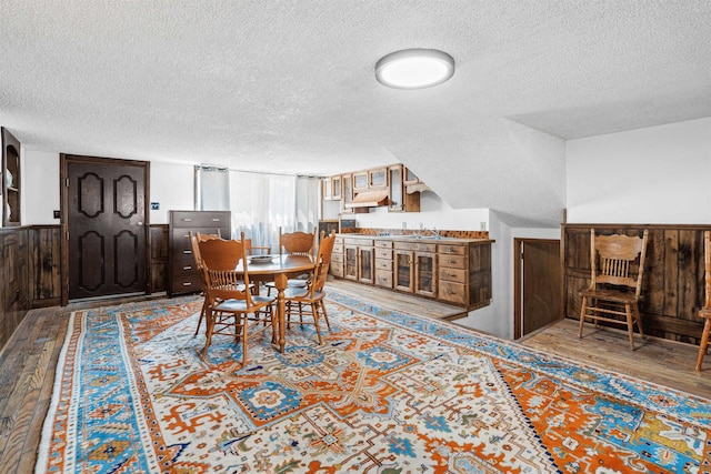 dining space with a textured ceiling, light hardwood / wood-style floors, and sink