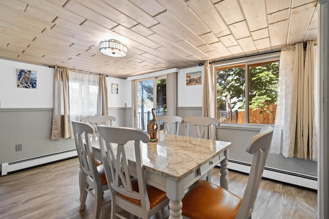 dining area featuring baseboard heating, wooden ceiling, and light wood-type flooring