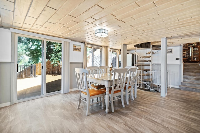 dining space with light wood-type flooring and wood ceiling