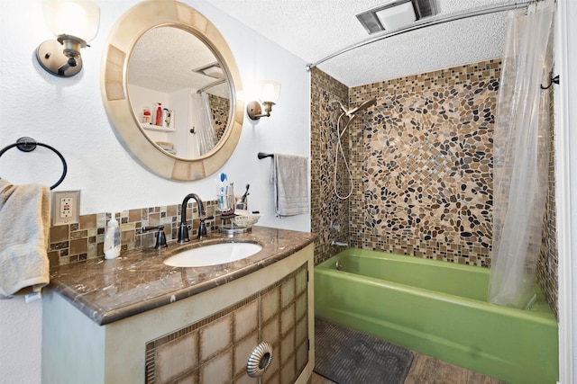 bathroom with backsplash, shower / tub combo with curtain, vanity, and a textured ceiling