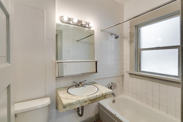 full bathroom with backsplash, toilet, tiled shower / bath combo, and sink