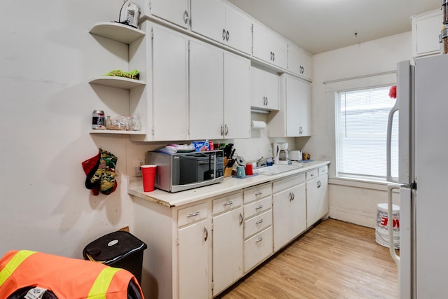 kitchen featuring sink, white cabinets, plenty of natural light, and white refrigerator