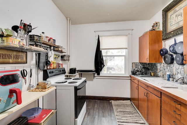 kitchen with white electric range, dark hardwood / wood-style floors, and tasteful backsplash