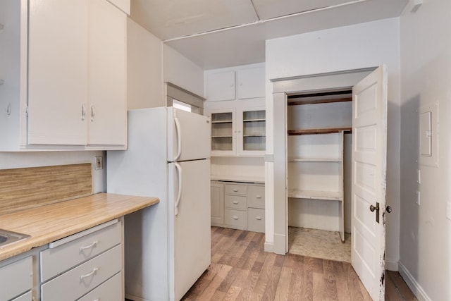 kitchen featuring light hardwood / wood-style flooring, white cabinets, and white refrigerator