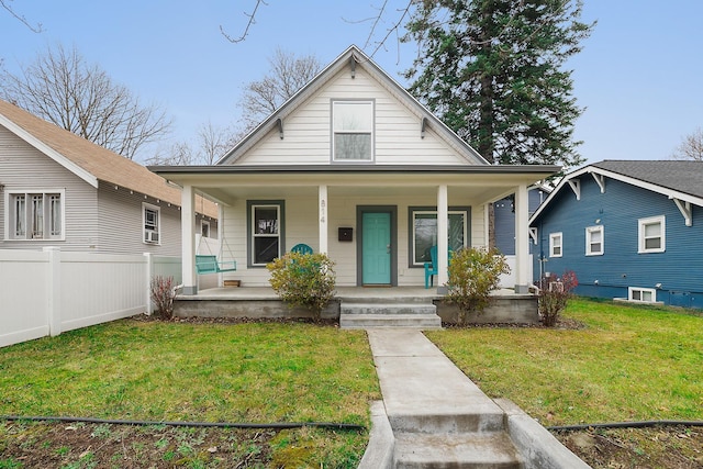 bungalow-style home with a front yard and covered porch