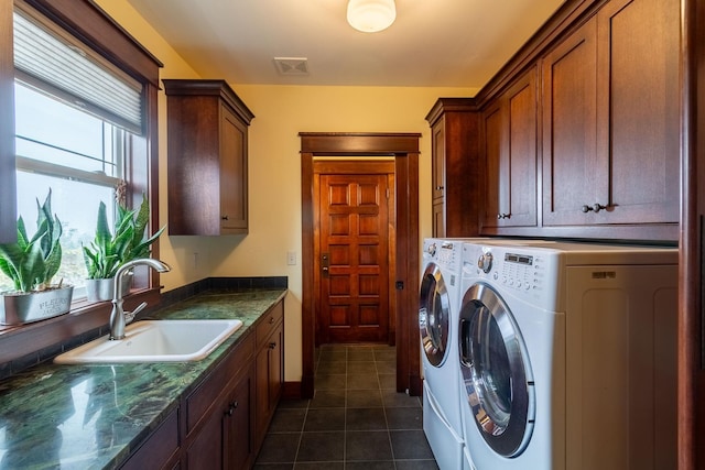 laundry area featuring cabinets, dark tile patterned floors, sink, and washing machine and dryer