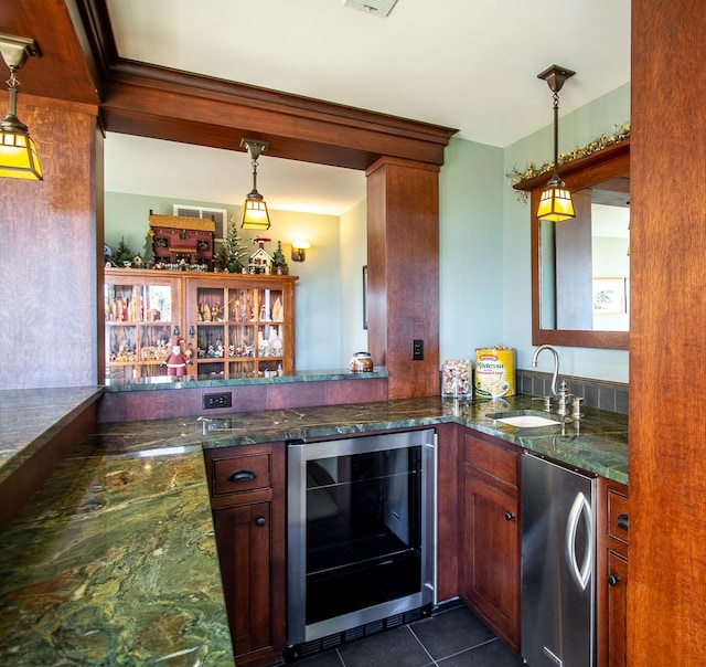 bar with dark tile patterned flooring, sink, dark stone countertops, fridge, and beverage cooler