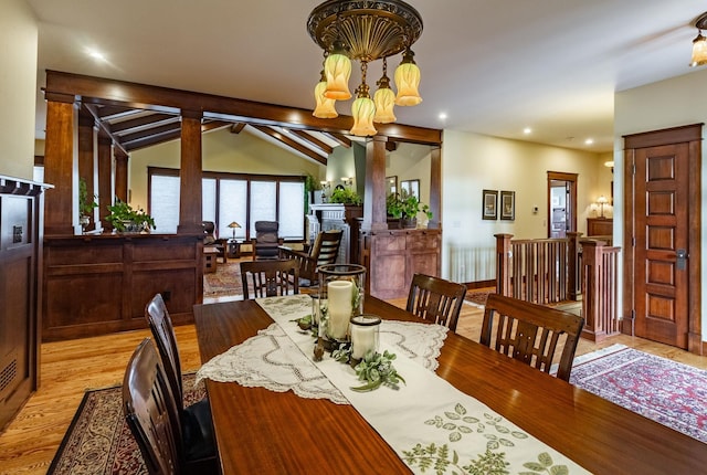 dining area featuring a chandelier, vaulted ceiling with beams, and light hardwood / wood-style flooring