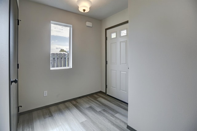 foyer entrance featuring baseboards and light wood-style flooring