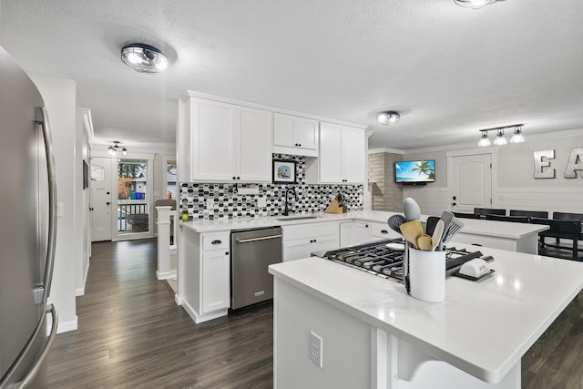 kitchen with sink, white cabinets, stainless steel appliances, and a kitchen island