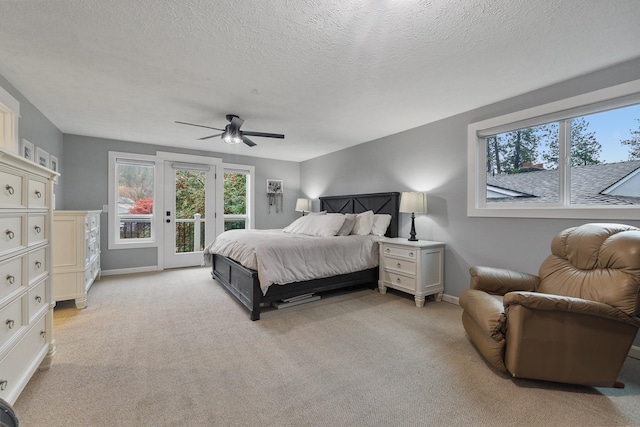 carpeted bedroom featuring access to outside, ceiling fan, and a textured ceiling