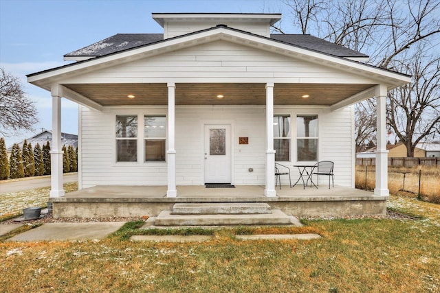 bungalow with covered porch and a front yard