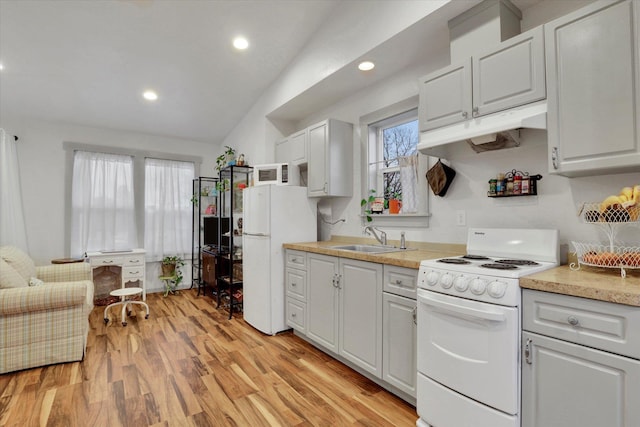 kitchen featuring white appliances, vaulted ceiling, sink, light hardwood / wood-style flooring, and white cabinets