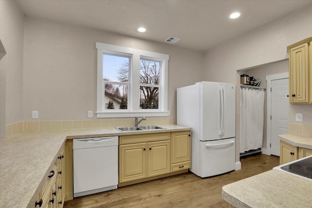 kitchen featuring white appliances, light hardwood / wood-style floors, and sink