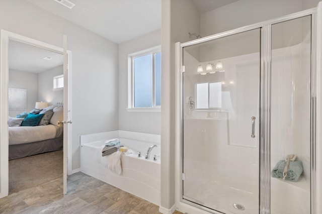 bathroom featuring shower with separate bathtub