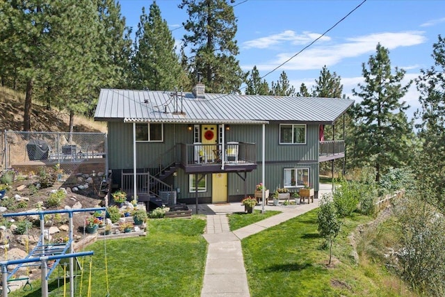 view of front of home featuring a patio, a balcony, and a front lawn