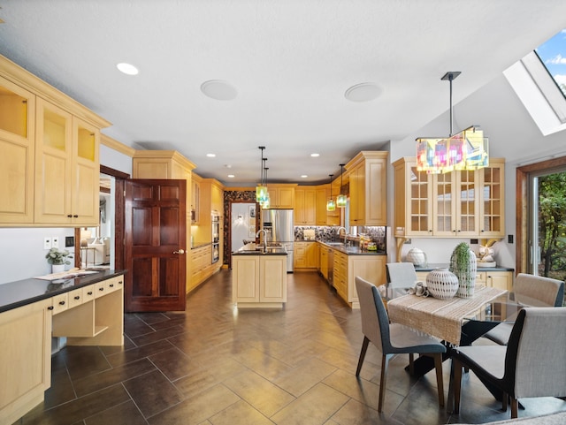 dining area with sink and vaulted ceiling with skylight