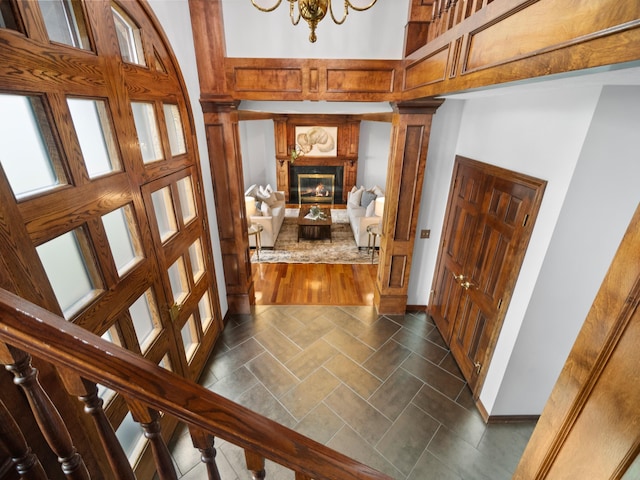 foyer entrance featuring a chandelier, a high ceiling, and decorative columns