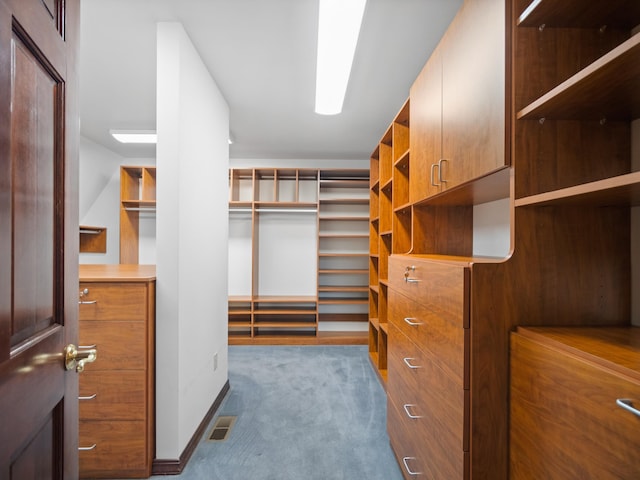 walk in closet featuring dark carpet