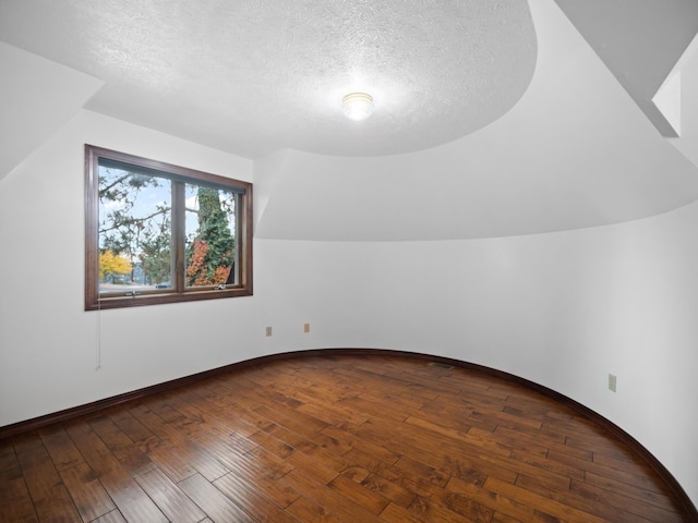 bonus room with hardwood / wood-style floors and a textured ceiling