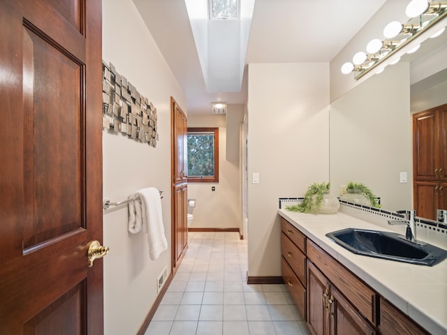 bathroom featuring tile patterned flooring, vanity, and toilet