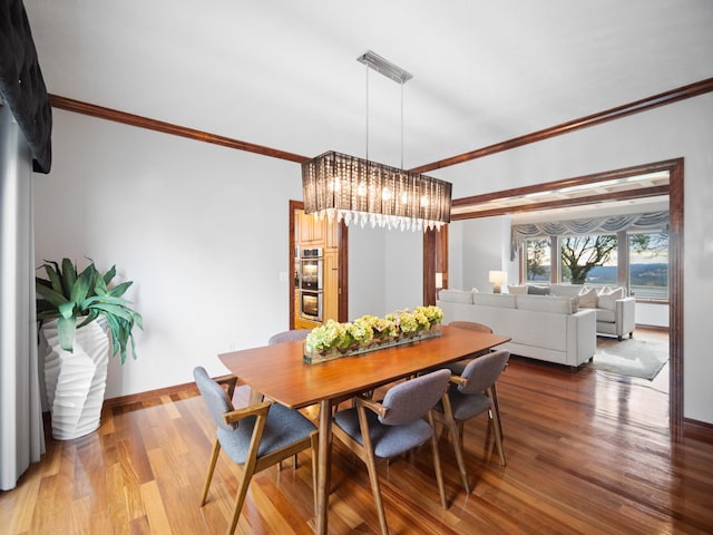 dining room featuring hardwood / wood-style floors, ornamental molding, and a notable chandelier