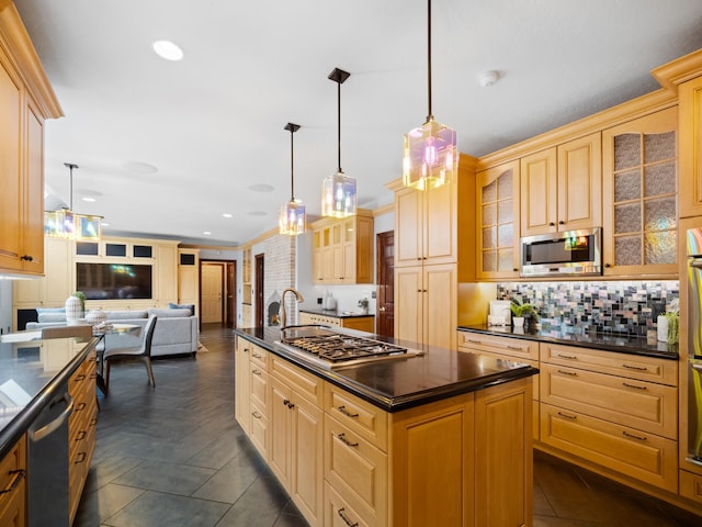 kitchen featuring backsplash, stainless steel appliances, light brown cabinets, decorative light fixtures, and a kitchen island